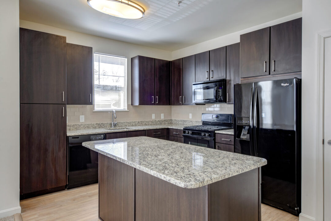 modern kitchen with dark wood cabinets and granite countertops