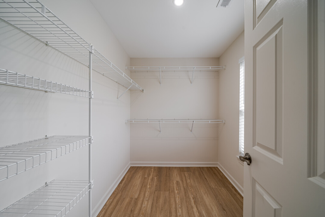 Walk-in closet with wood-look flooring, light-colored walls, a white ceiling, and white wire shelving.