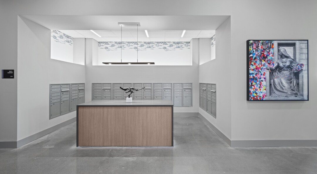 Mail room with wall-mounted mailboxes, and a central sorting counter.