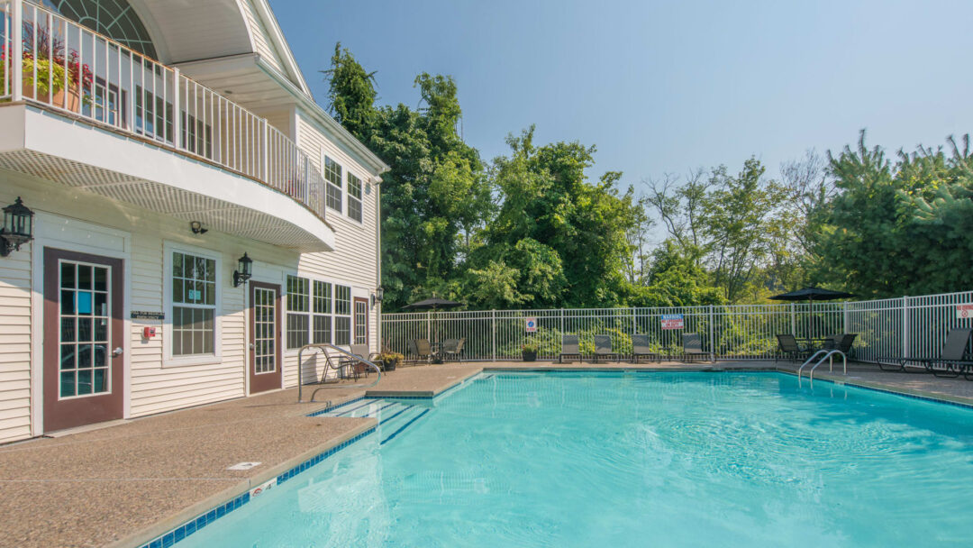 large pool area with swimming pool with 2 steps of stairs and fenced