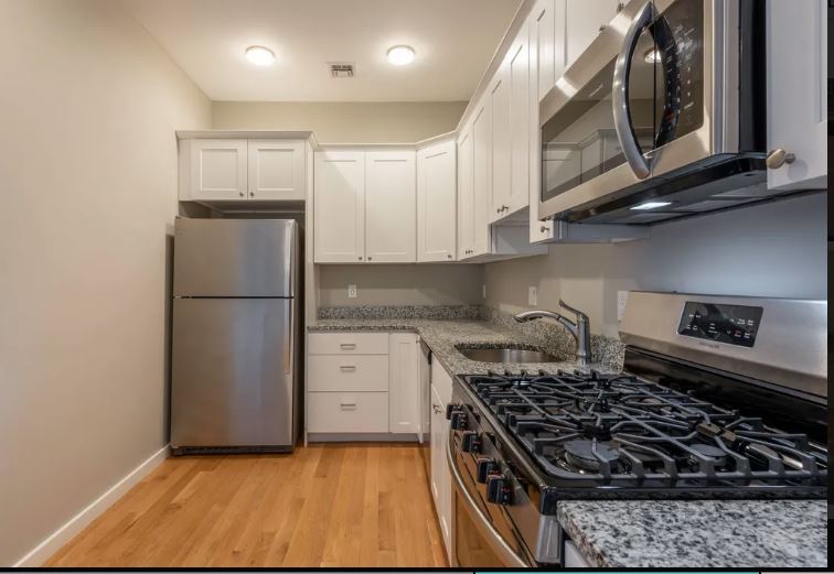 598 - 600 North St. modern kitchen with stainless steel appliances, wood floors and white cabinets