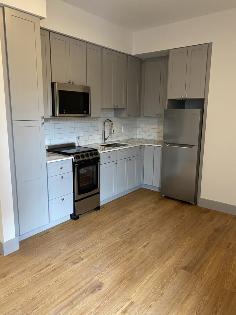modern kitchen with stainless steel appliances and wood floors