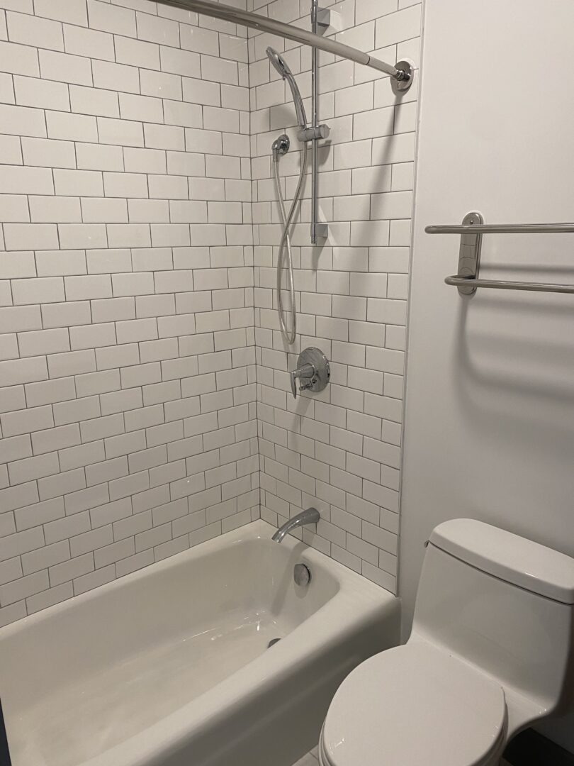 bathroom with white tile shower and while toilet