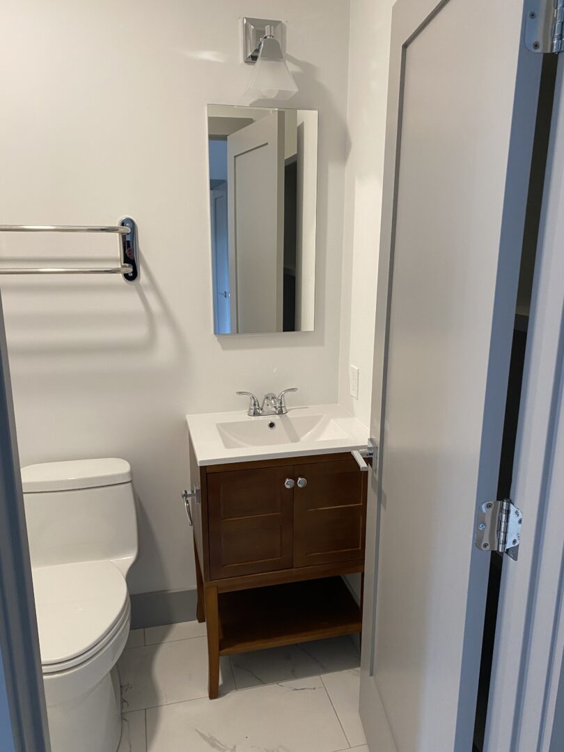 modern bathroom with white walls and cherry vanity
