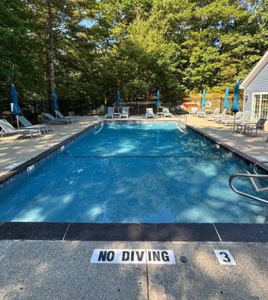 large resort-style pool with sun loungers and umbrellas