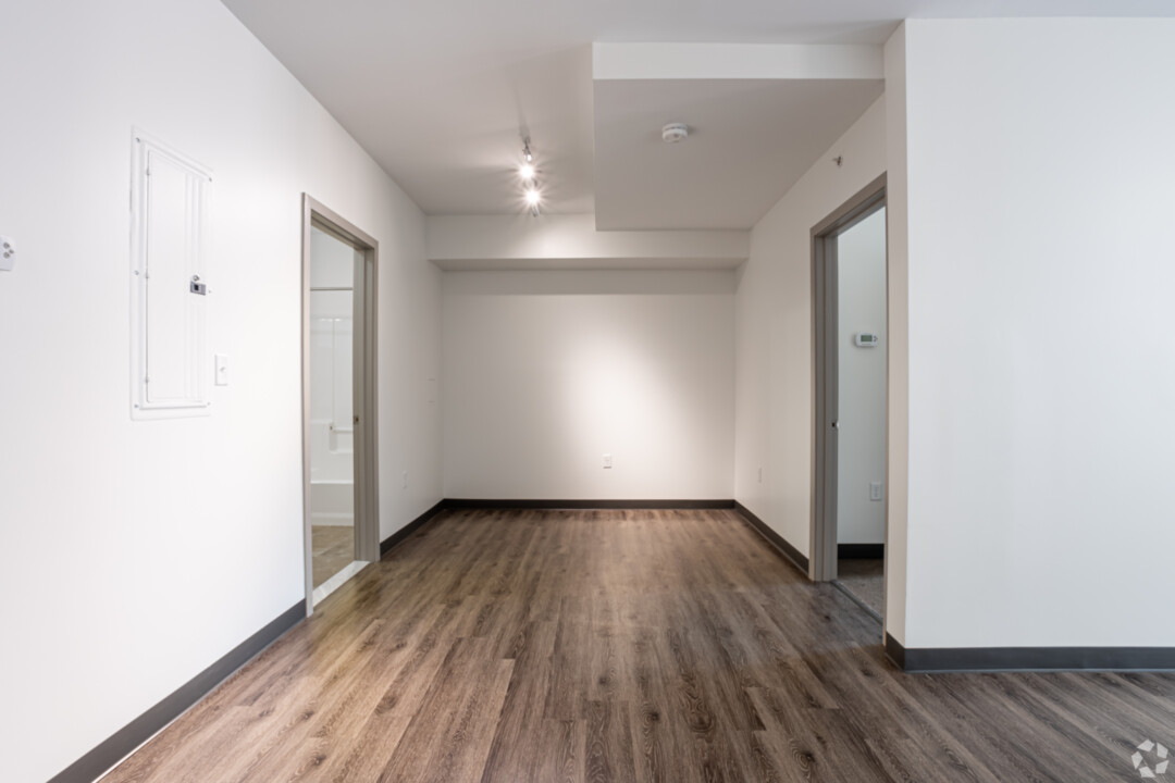A space with wood-style flooring, white walls, recessed lighting, and a white ceiling.