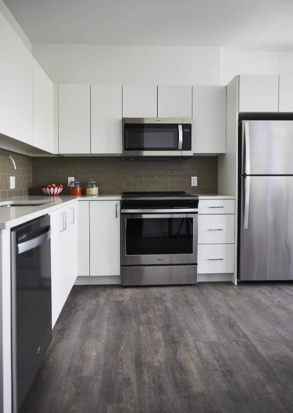 Kitchen with white cabinets, stainless steel appliances, and a tile backsplash.