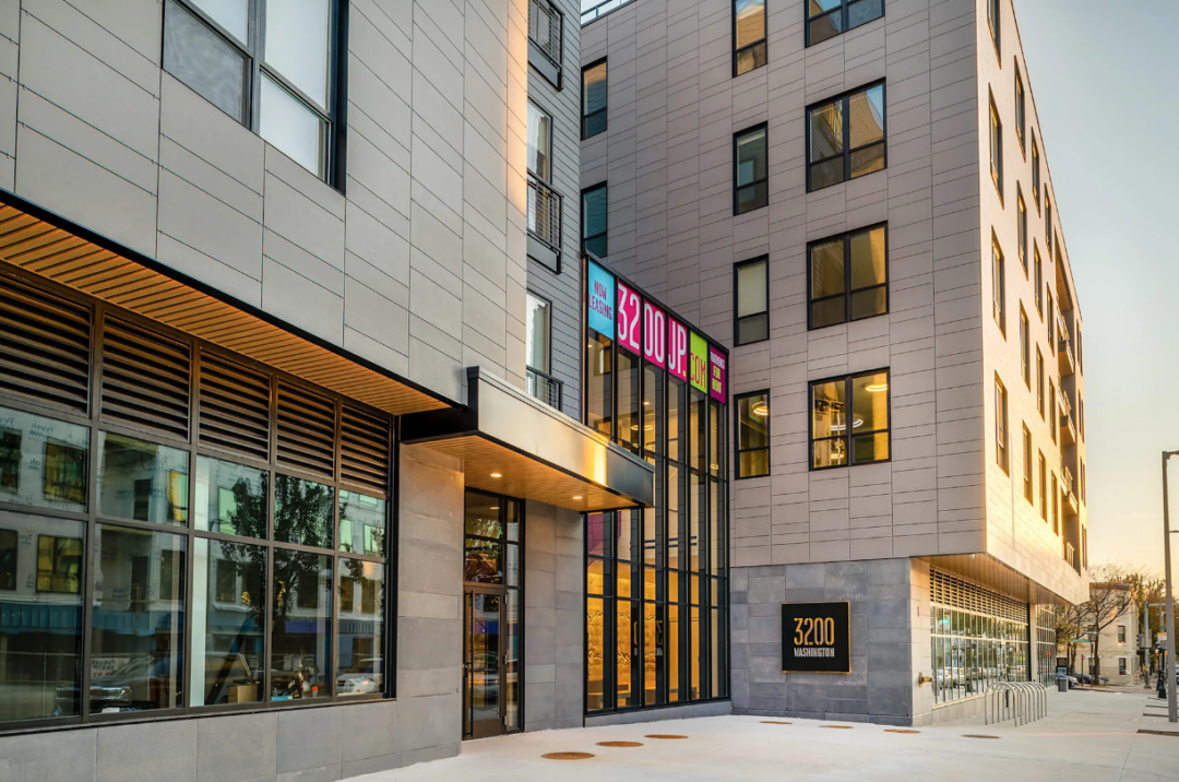 Apartment building entrance with tall glass windows and a 3200 Washington sign.