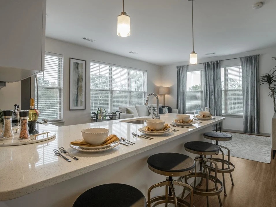 Kitchen breakfast bar with place settings, stools, and pendant lighting.