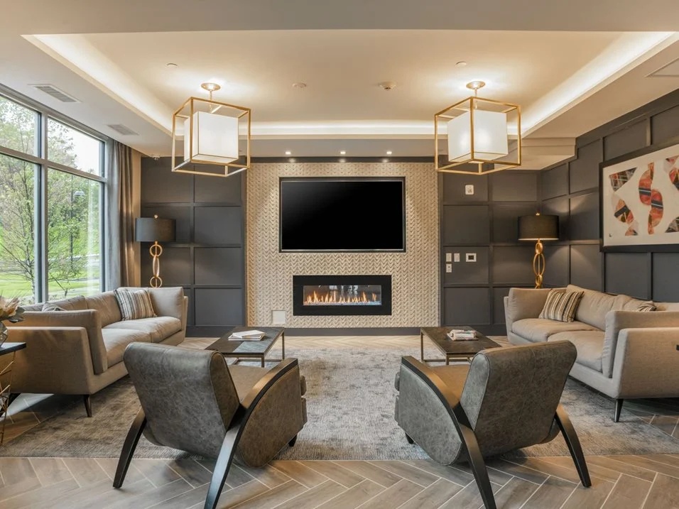 Lounge with chairs, a fireplace, and a television.
