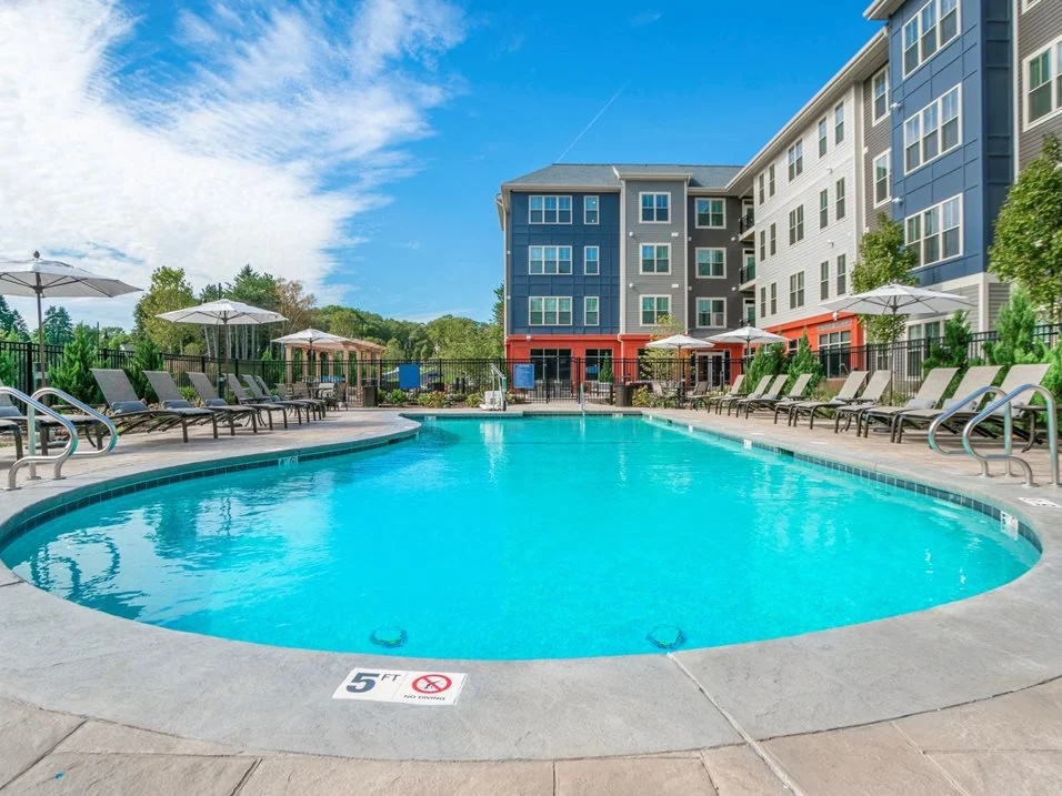 Outdoor swimming pool beside an apartment building.